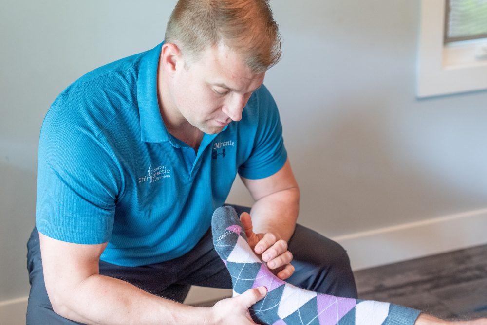 Chiropractor assessing foot injury from running